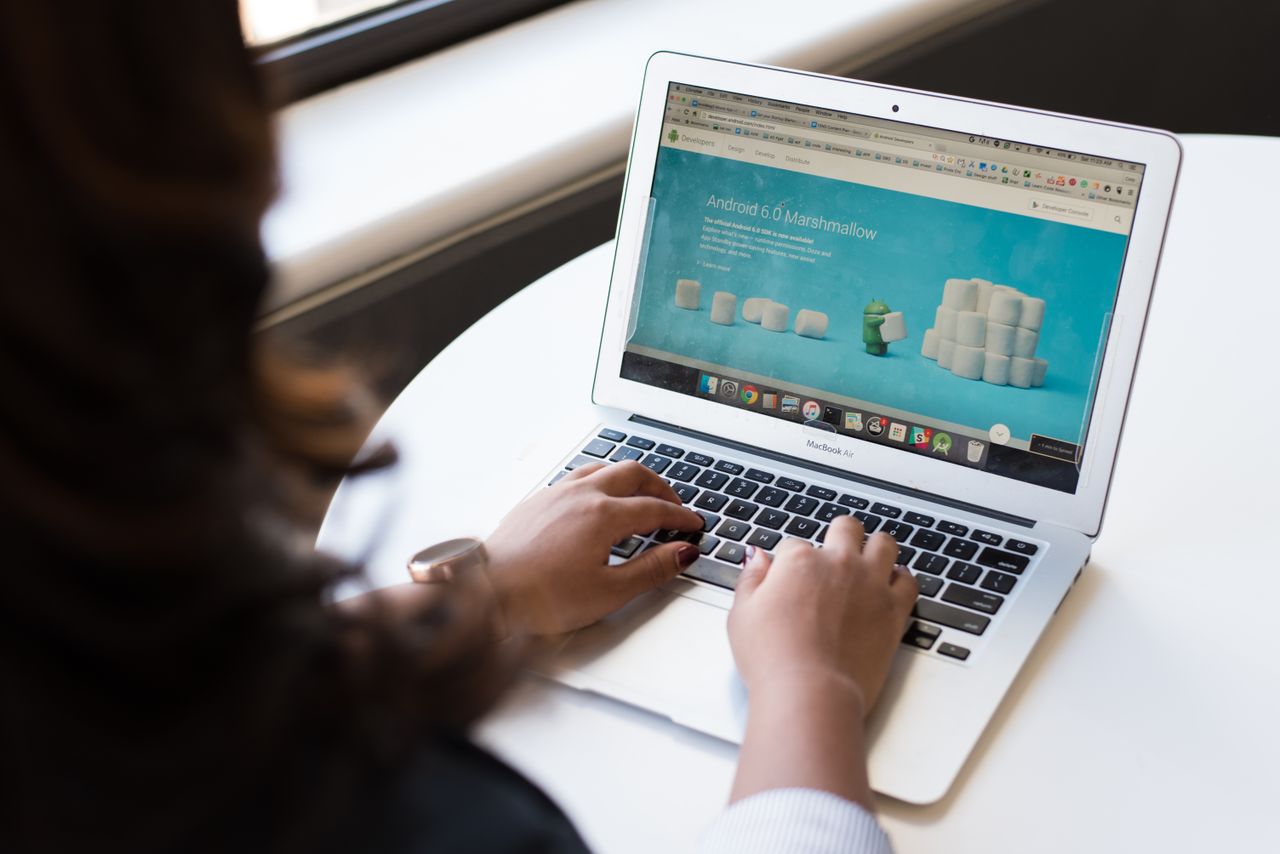 services-01 Businesswoman working on laptop with Android 6.0 Marshmallow webpage open.